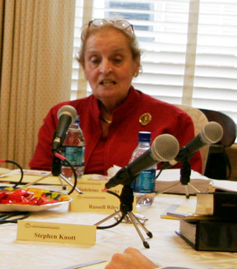 Madeleine Albright sits behind a microphone