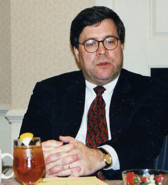 William Barr behind a microphone