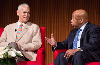Julian Bond and John Lewis seated in red chairs talking