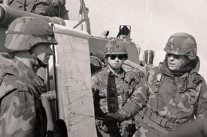 US officer in combat uniform pointing at map