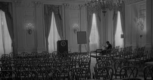 Robert McNamara sitting by himself in an empty room