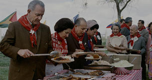 LBJ with Lady Bird filling up a plate at a BBQ