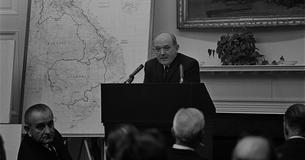 Dean Rusk standing behind a podium next to a map of Vietnam