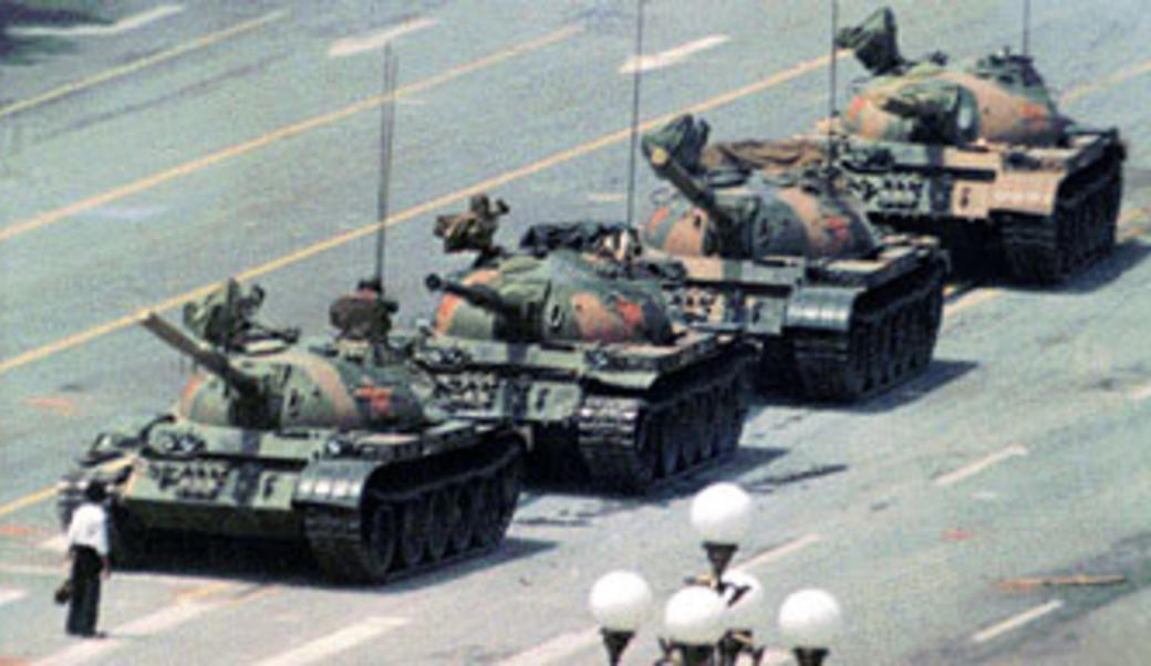 Man stands in front of column of tanks